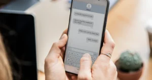 mãos de uma mulher segurando um celular em conversa com chatbot