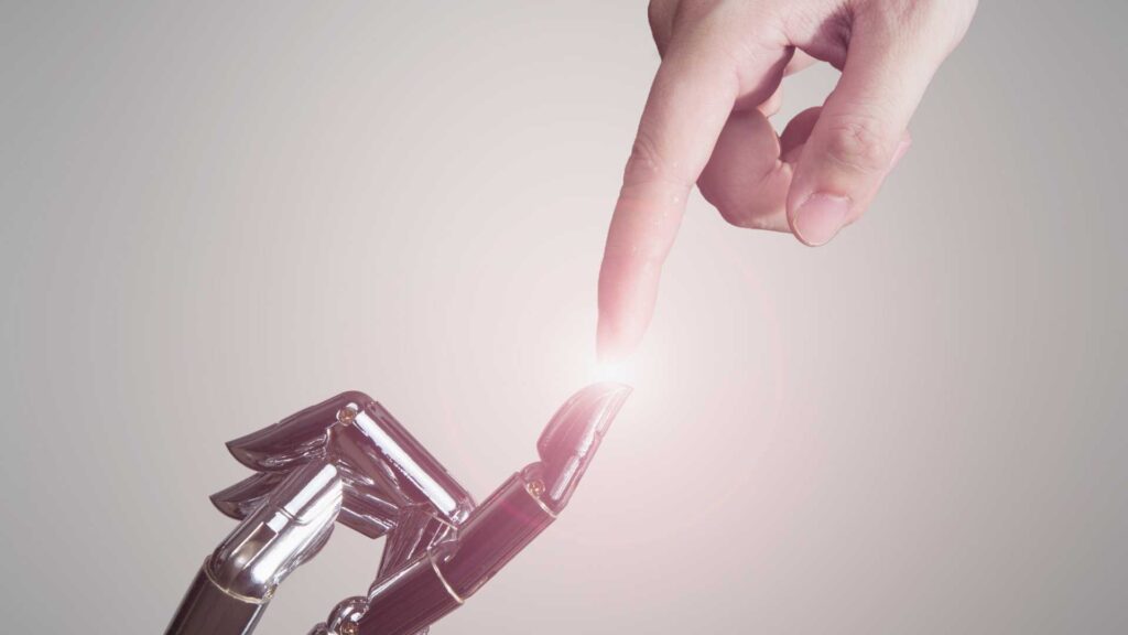 mão robótica tocando o dedo indicador de uma mão humana