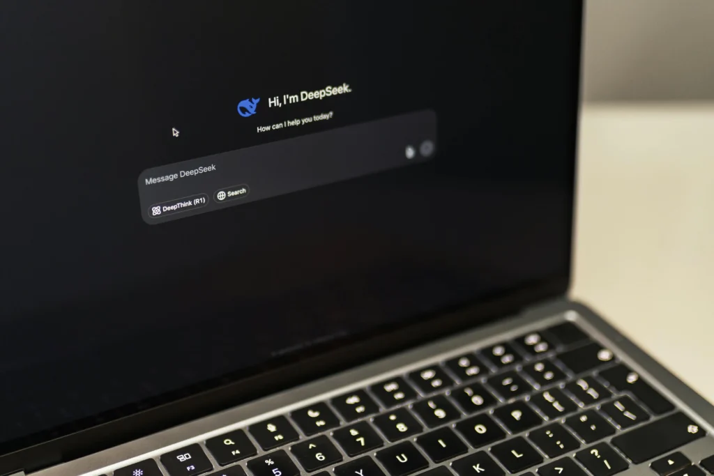 Tela de notebook exibindo a interface do chatbot DeepSeek com teclado iluminado em destaque